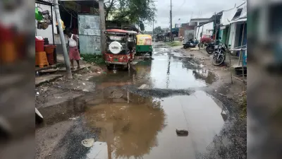 सड़क पर गड्ढे से हिचकोले खा रहे वाहन, बह रहा नाले का पानी