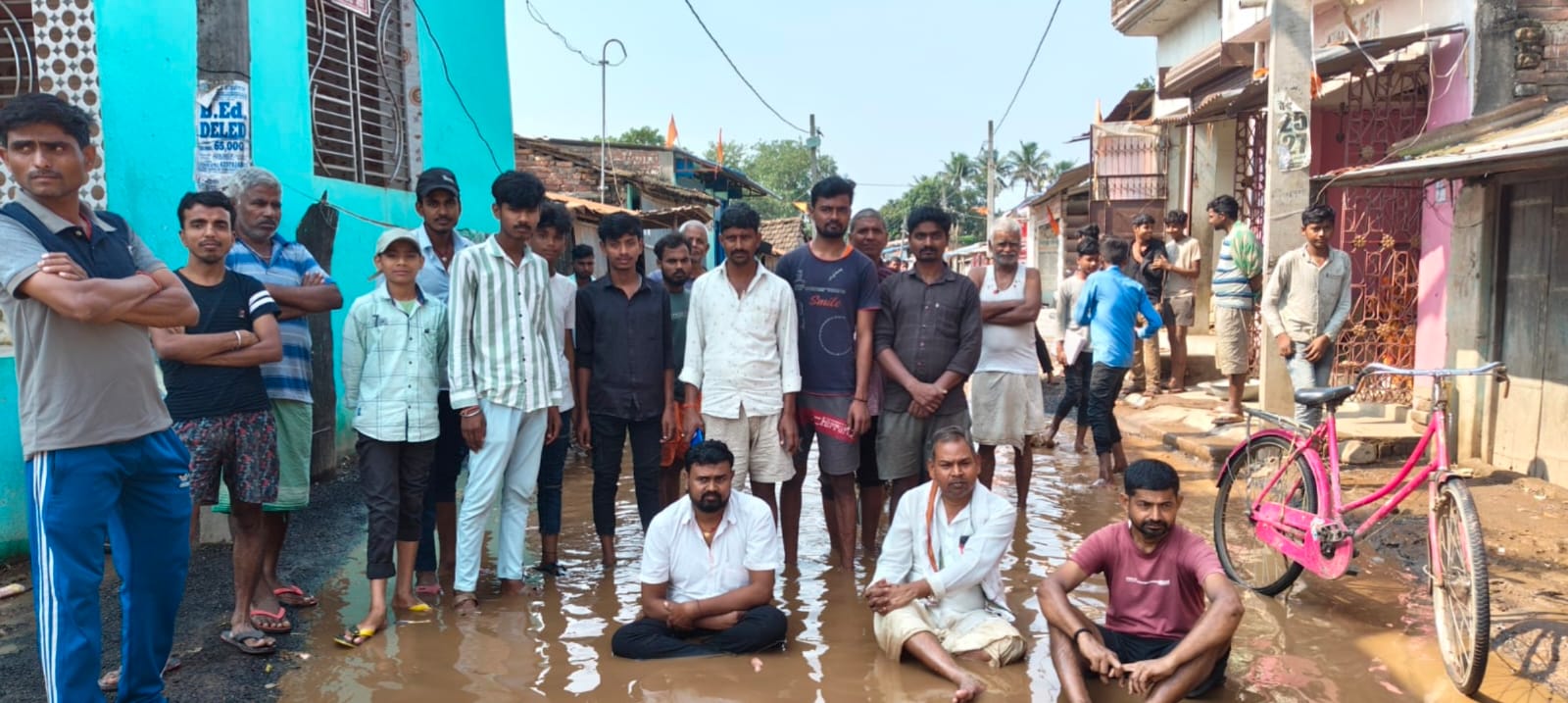 मंजौरा बाजार की जर्जर सड़क पर फूटा लोगों का गुस्सा, पानी में बैठकर किया विरोध प्रदर्शन