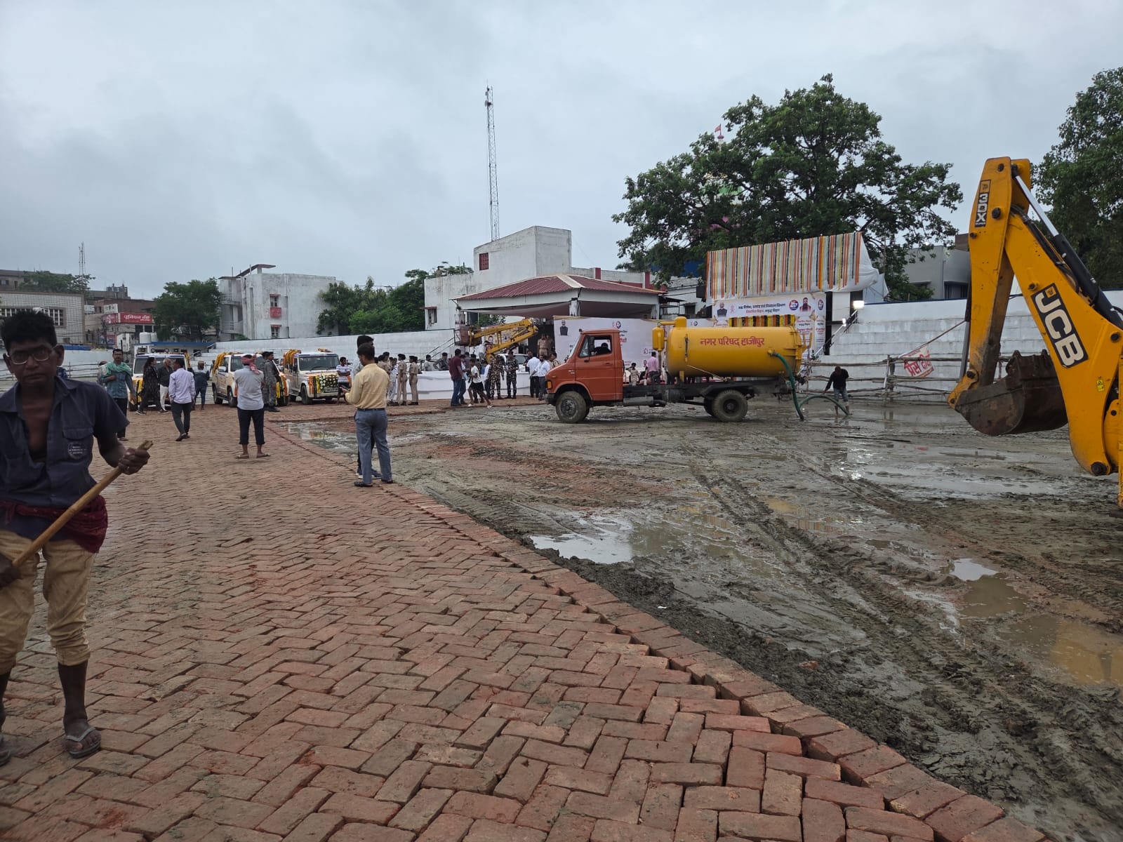 कार्यक्रम स्थल के पास कीचड़ साफ सफाई करते कर्मी