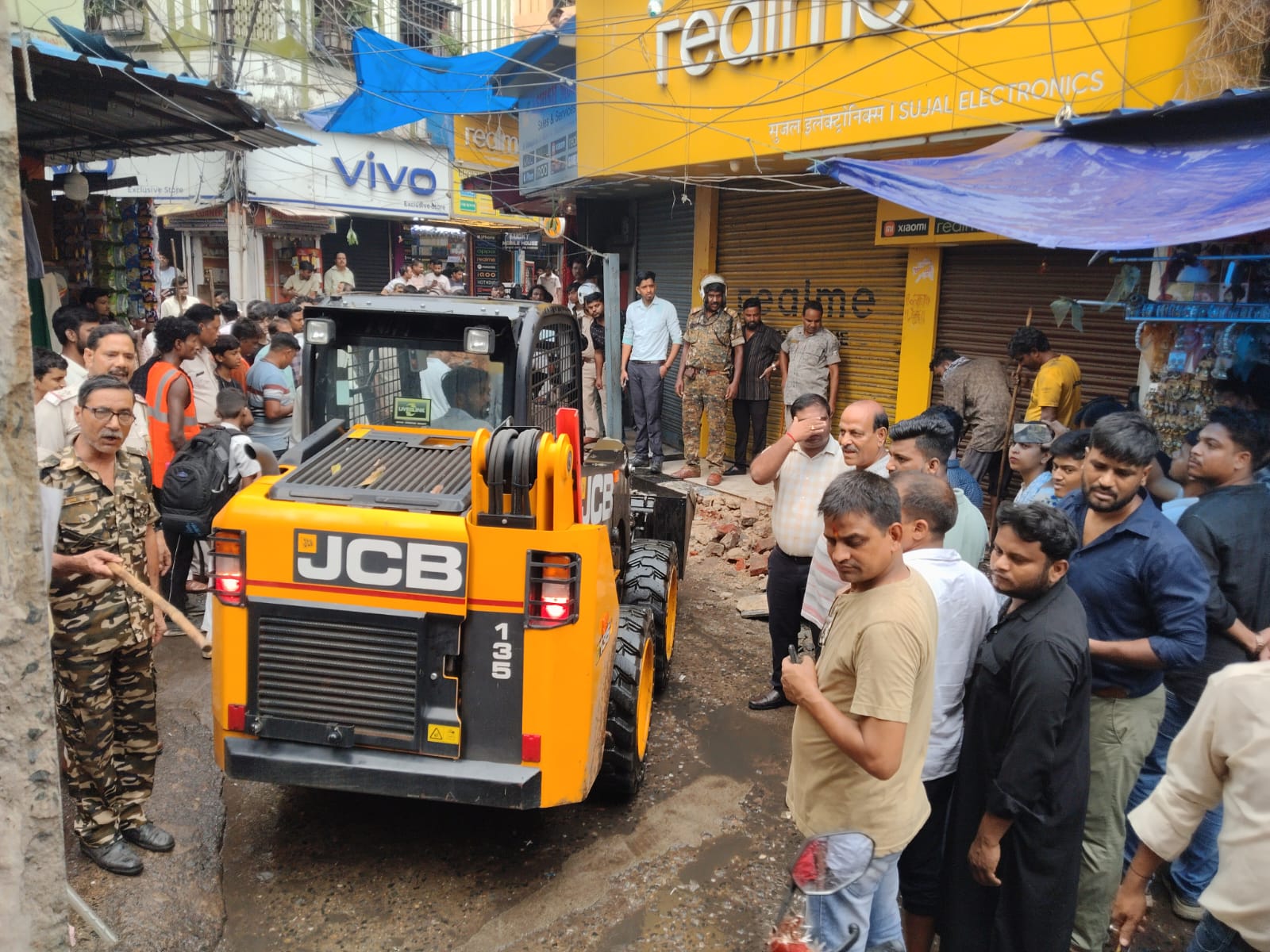 झरिया गांधी रोड की नालियों से निगम ने हटाया अतिक्रमण, दुकानदारों में हड़कंप
