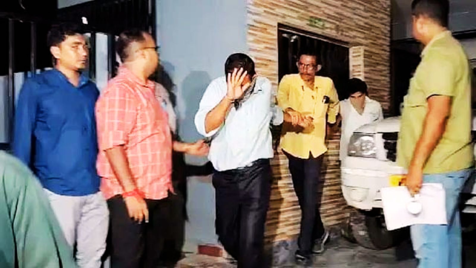 गेस्टहाउस से हिरासत में लिये गये लोग और सिविल ड्रेस में पुलिसकर्मी.