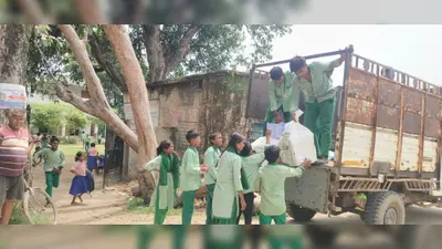 मजदूर की जगह स्कूली बच्चे गाड़ी से उतार रहे हैं कॉपी-किताब