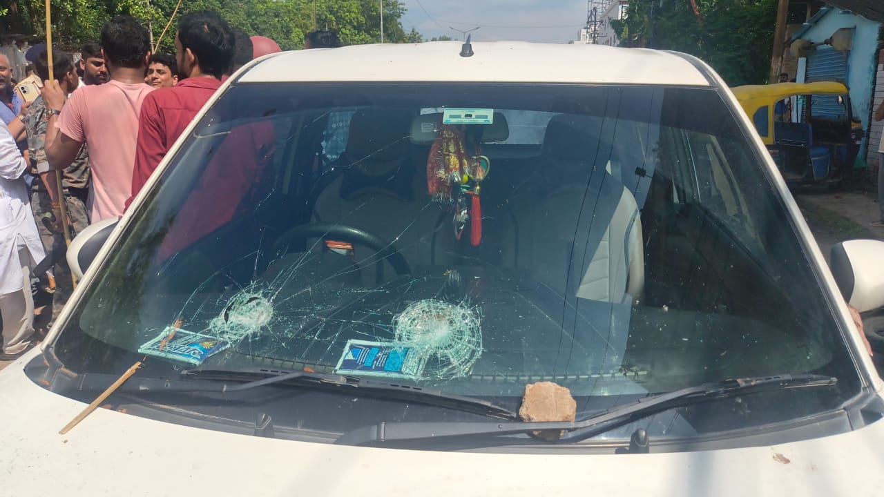 पथराव में क्षतिग्रस्त हुई सड़क पर खड़ी गाड़ी
