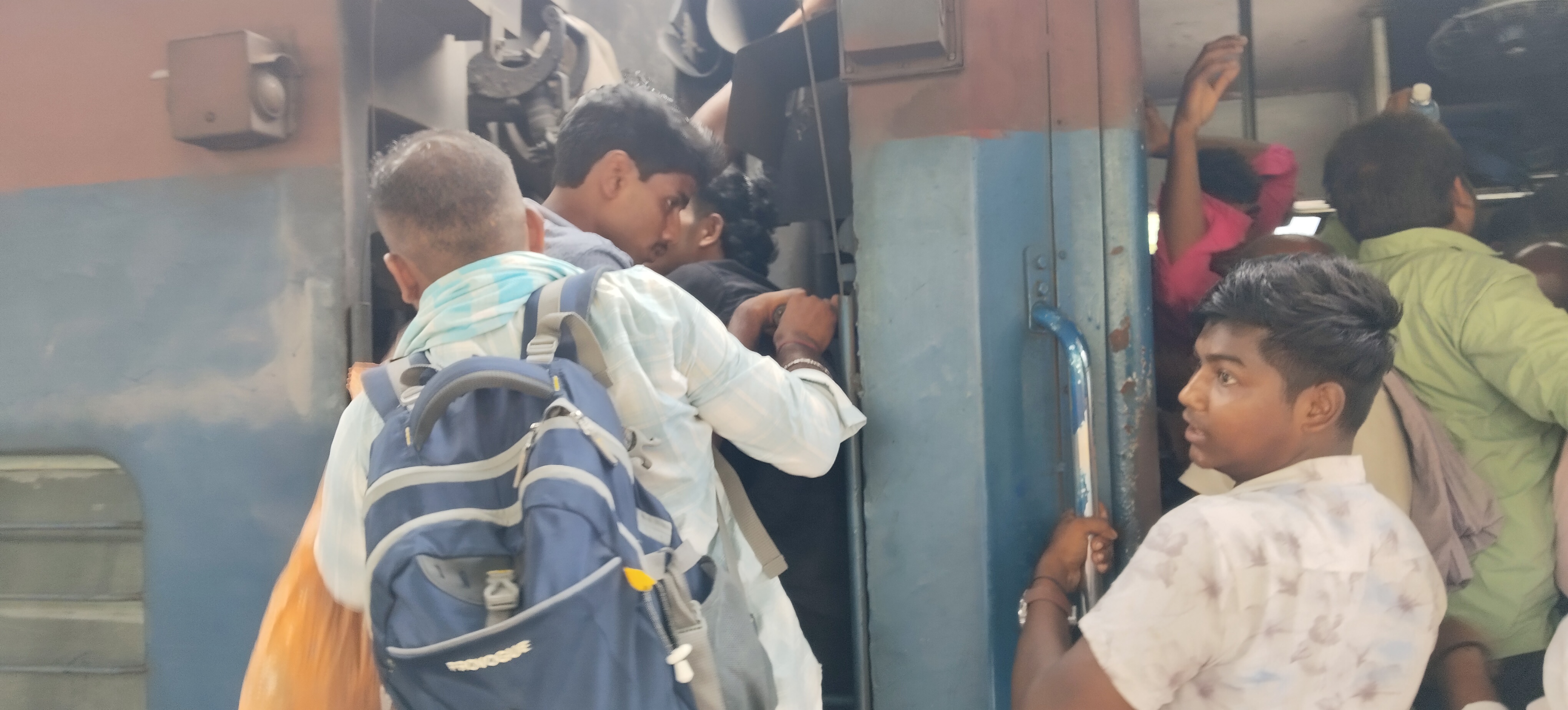 धुलियान पैसेंजर: सीट तो दूर, खड़े होने की जगह नहीं, कपलिंग पर लटककर सफर कर रहे यात्री