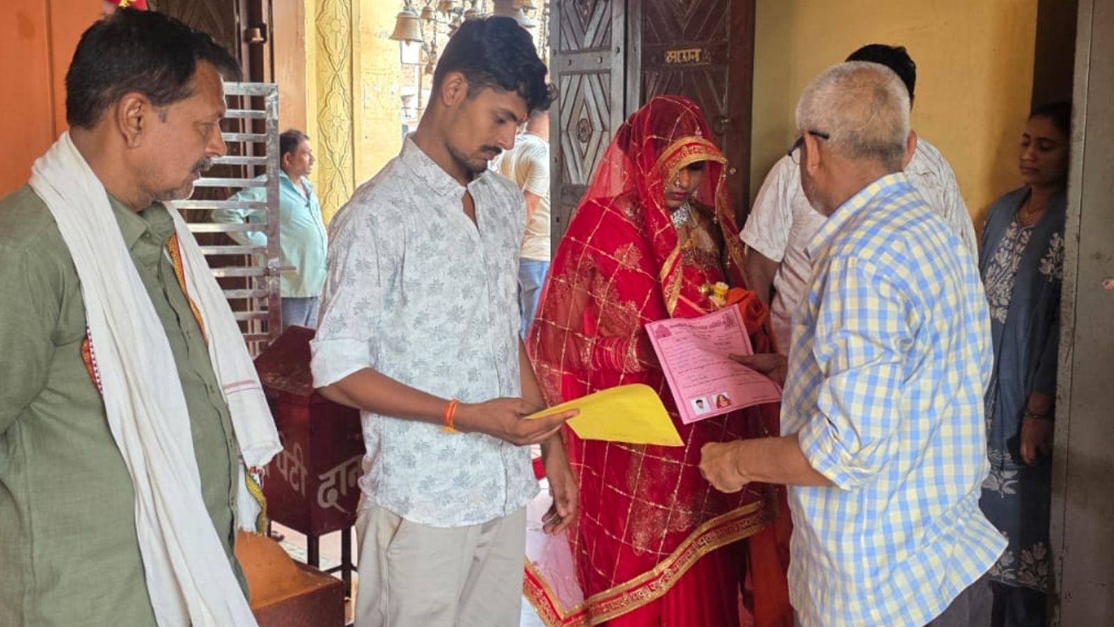 शादी का प्रमाणपत्र देते मंदिर के कर्मचारी