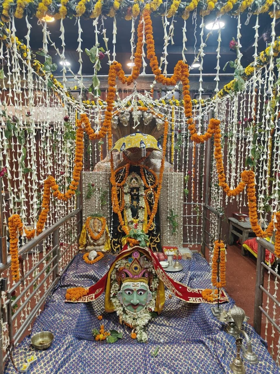 भगवान शिव के शिवलिंग को हरे रंग का एक बेहद सुंदर और शांत मुखौटा से सुसज्जित किया गया है. जिस पर लाल 'जय महाकाल' लिखा वस्त्र और फूलों की मालाएं लिपटी हुई हैं.  इसके ठीक पीछे नाग-छत्र के साथ मुख्य विग्रह और चारों तरफ छत से लटकती सफेद व गेंदे के फूलों की अनगिनत लड़ियों की अलौकिक सजावट पूरे परिवेश को अत्यंत पवित्र और भक्तिमय बना रही है.