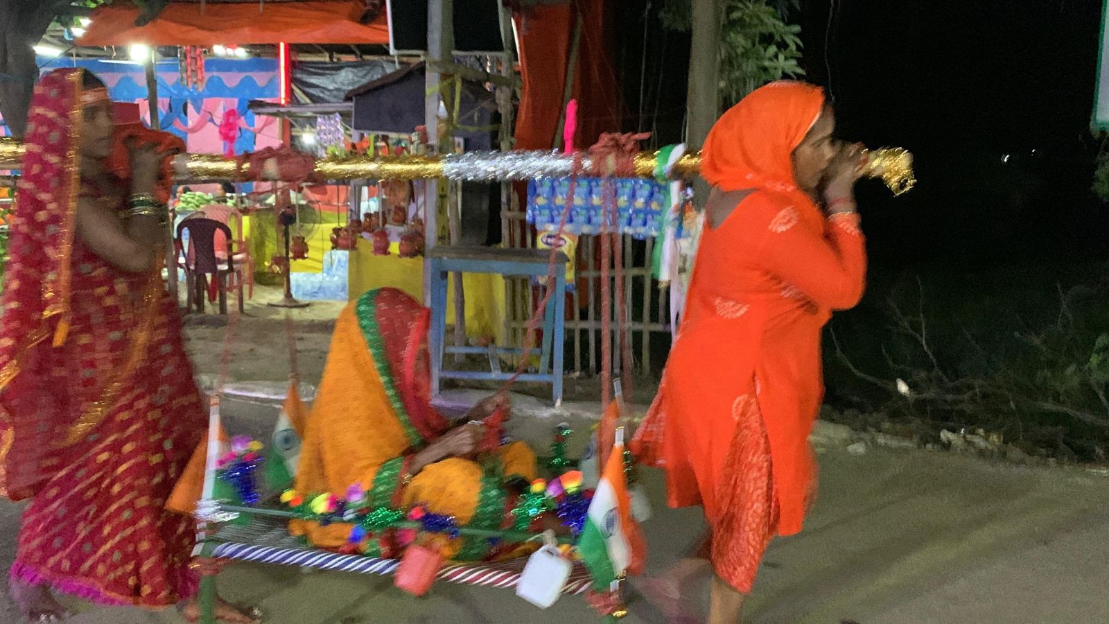 85वर्षीया रामकुमारी को पालकी में बाबाधाम ले जाते पड़ोसी.