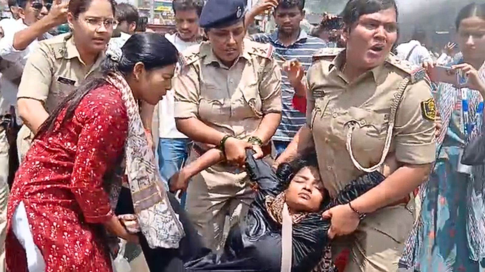 बेहोश छात्रा को वैन में ले जाती पुलिस 
