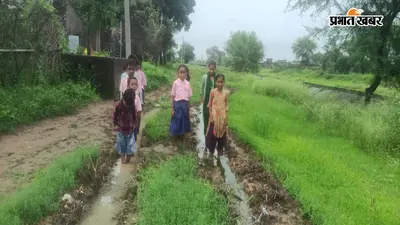 गढ़वा : बारिश में दलदल बनी सड़क, एक हाथ में किताब तो दूसरे में चप्पल लेकर स्कूल जाने को मजबूर हैं बच्चे