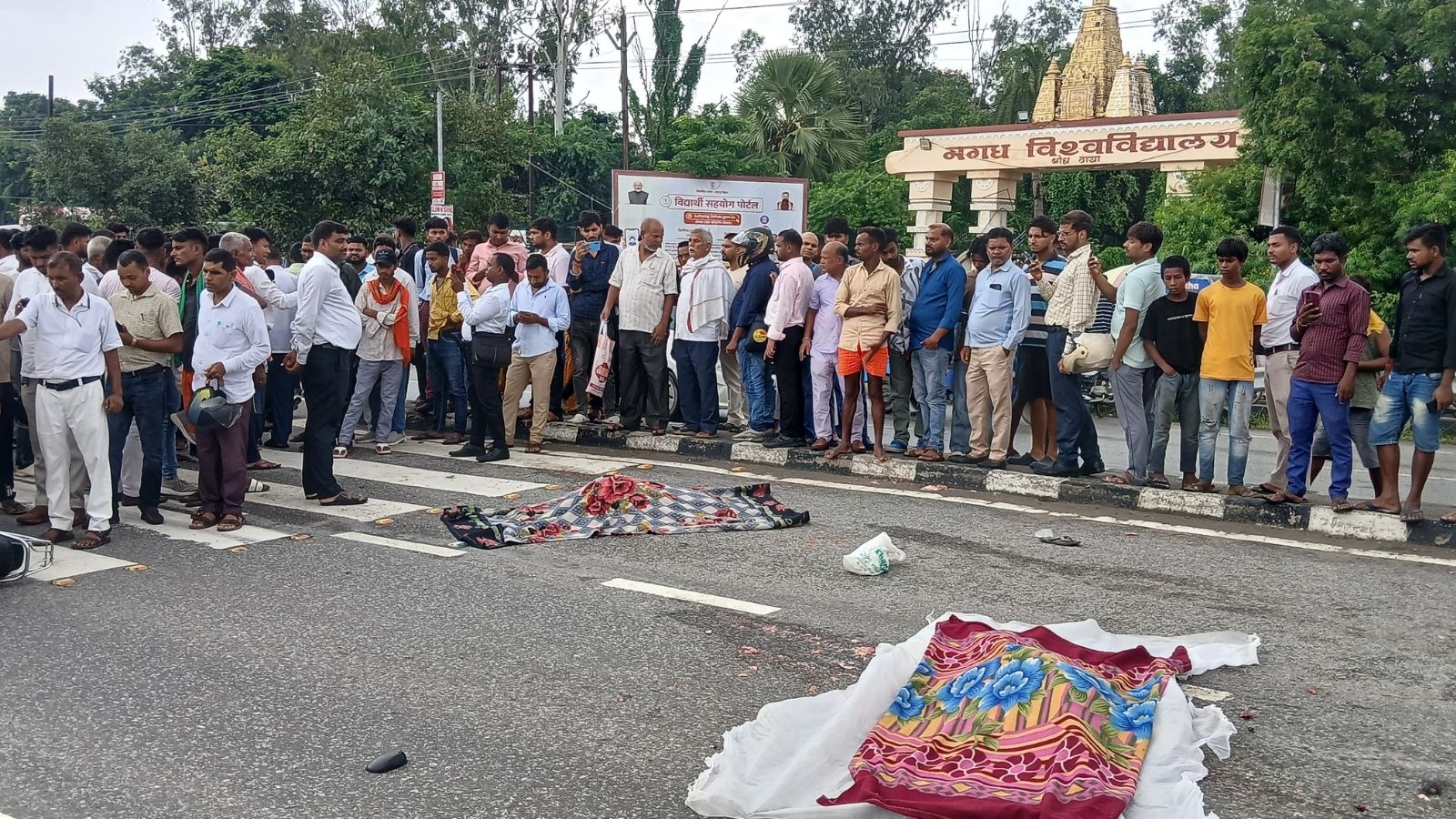 मगध विश्वविद्यालय के मुख्य गेट के सामने हादसे के बाद सड़क पर जुटी भीड़ और पुलिस