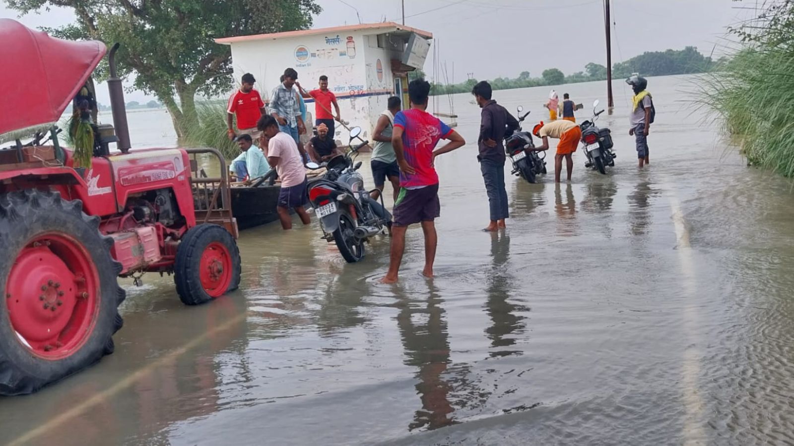 बाढ़ प्रभावित इलाके से नाव के सहारे सुरक्षित स्थान पर जाते ग्रामीण. फोटो - प्रभात खबर