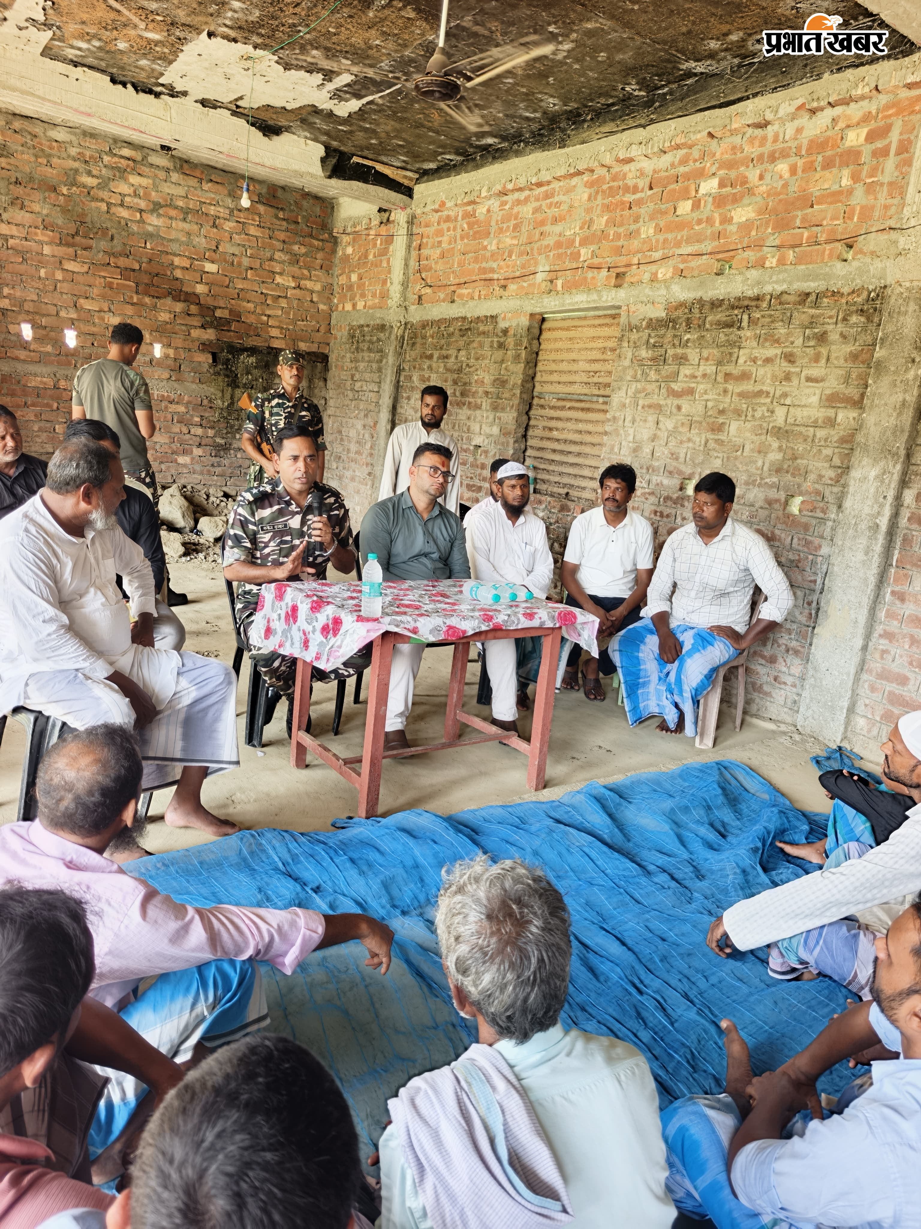 ग्रामीणों के साथ बैठे असिस्टेंट कमांडेंट मनोज कुमार, मुखिया प्रतिनिधि गणेश कुमार सिंह। | Prabhat Khabar Network
