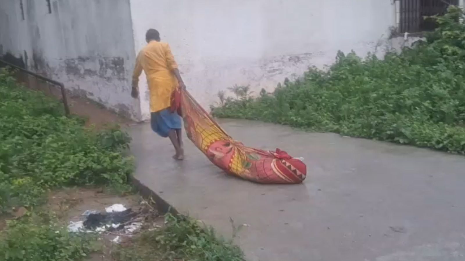 शव को घसीट कर ले जाता व्यक्ति