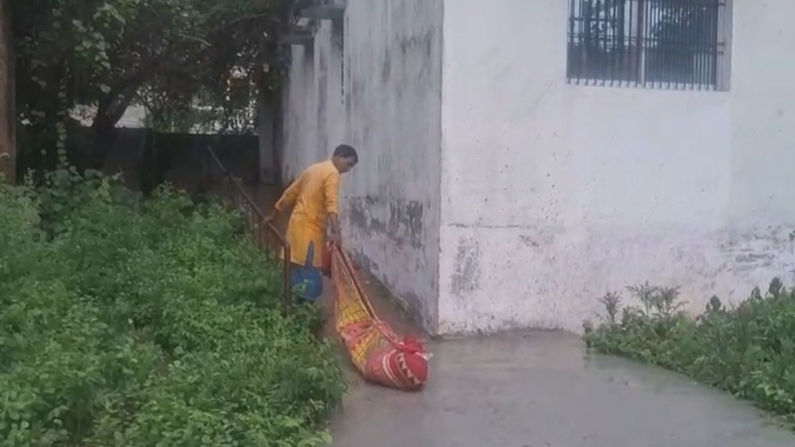 शव को घसीट कर ले जाता व्यक्ति
