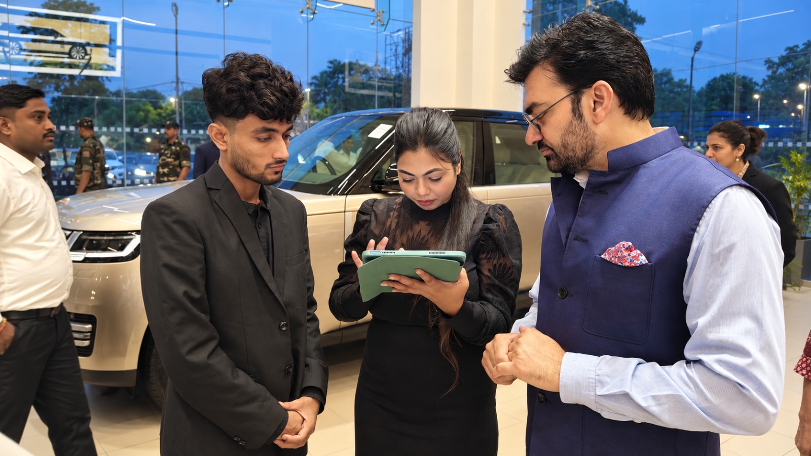 JLR Exclusive Showroom में कार के बारे में जानकारी लेते लोग