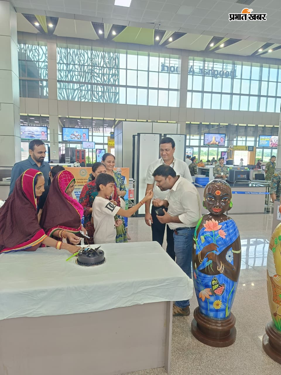 केक काट कर खुशी मनाते यात्री साथ में एयरपोर्ट निदेशक अभिजीत शर्मा, टर्मिनल मैनेजर सूर्या | Prabhat Khabar Network
