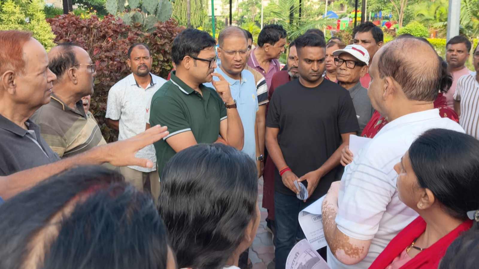 पार्क में लोगों को फरार इनामी अपराधी की पोस्टर देते एसएसपी